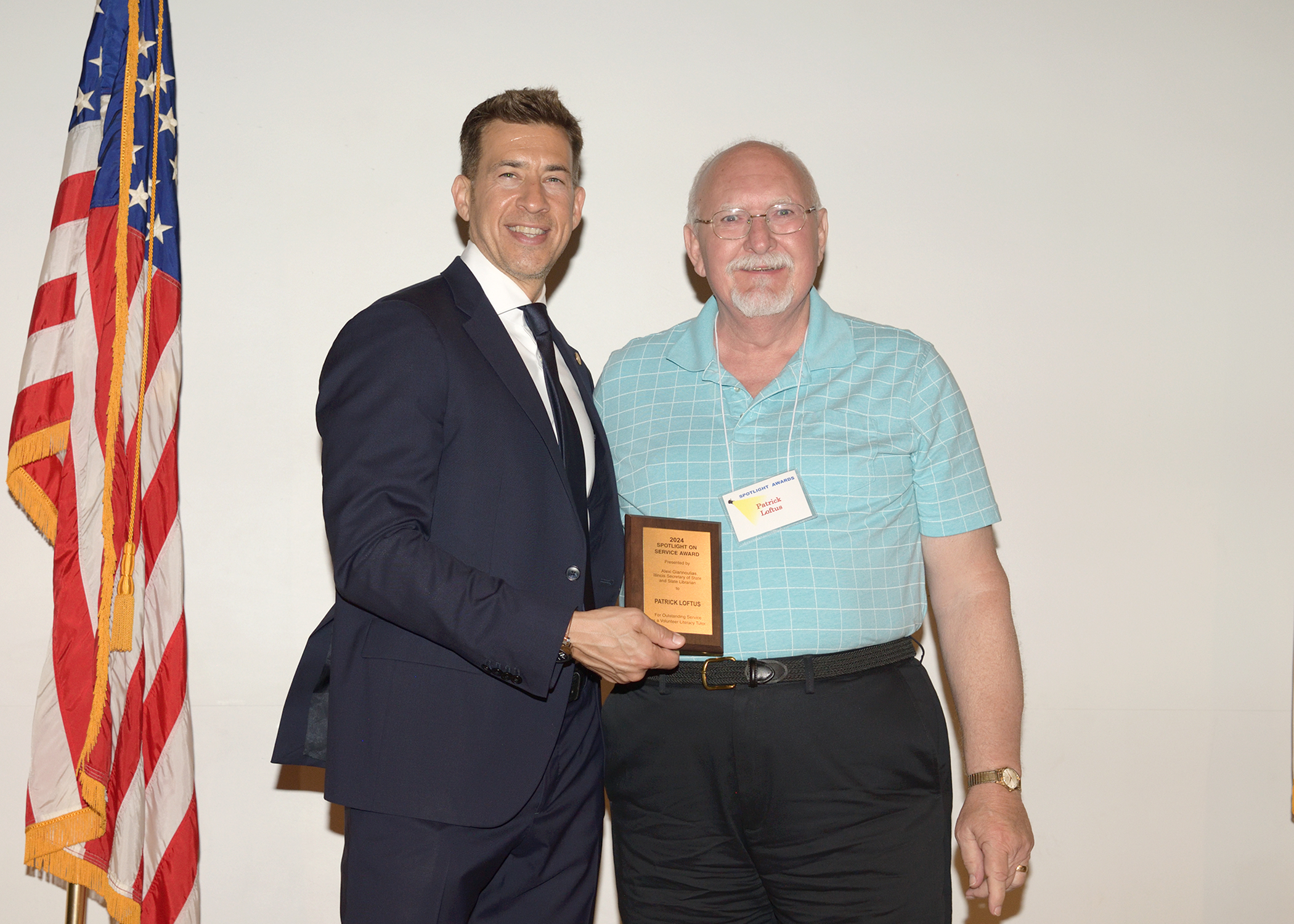 Secretary of State and State Librarian Alexi Giannoulias presents L&C Project READ volunteer Patrick Loftus with a Spotlight on Service award. Submitted photo.
