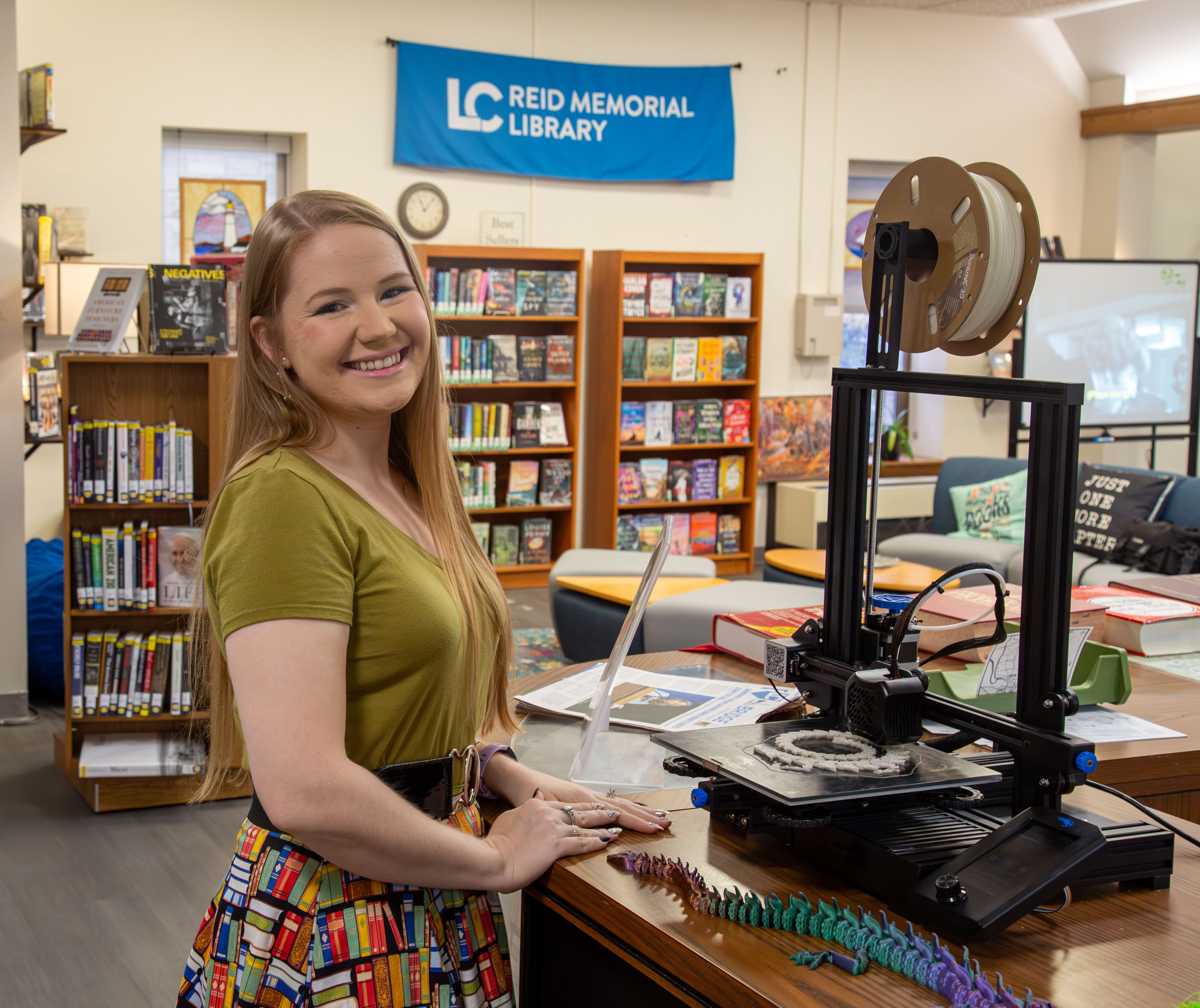 Library Services Assistant Julie Laakko pictured by the new 3D printer at the Circulation Desk. Photo by JARED SMILACK/L&C MARKETING & PR