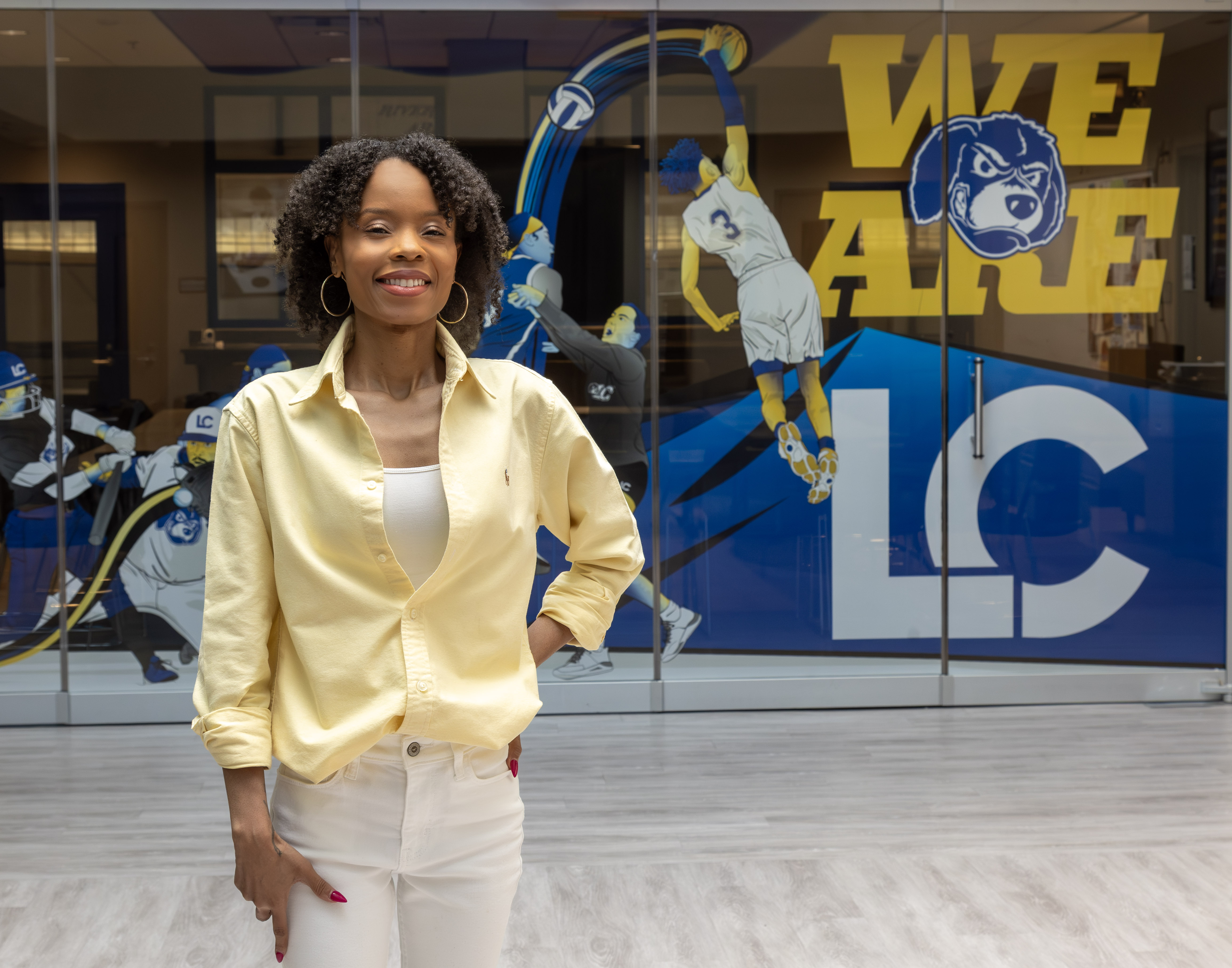 LC Graphic Designer Tanja Jackson’s Skybox Window design won a Silver Paragon Award at a recent National Council for Marketing & Public Relations National Conference in Washington, DC. Jackson is shown here with her original design, located in River Bend Arena. Photo by JAN DONA/LC Marketing & PR