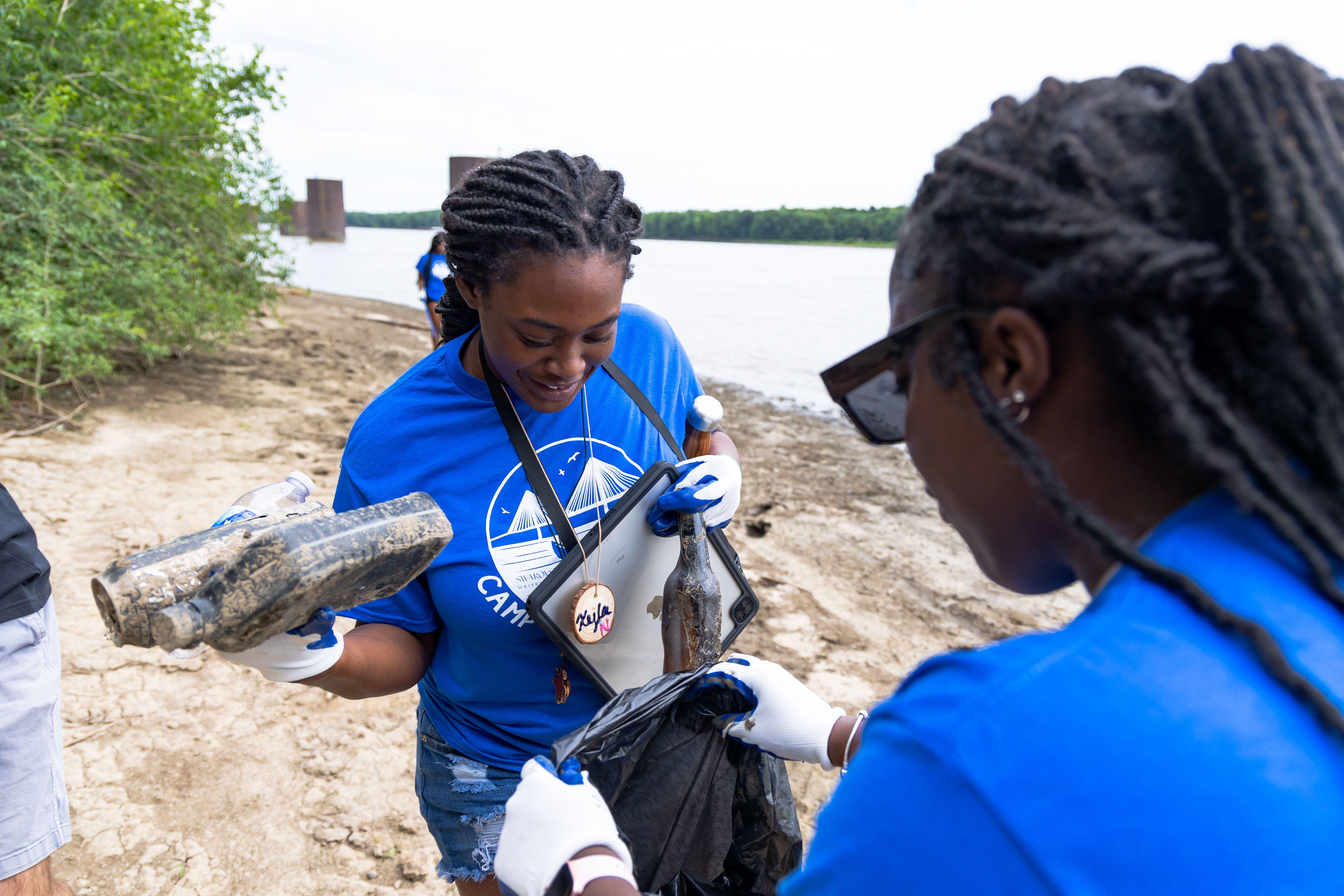 Cahokia High School Student Xyla Nixon cleans up trash along the Mississippi River during Camp Waterschool at the National Great Rivers Research and Education Center. Photo by Route 3 Films.