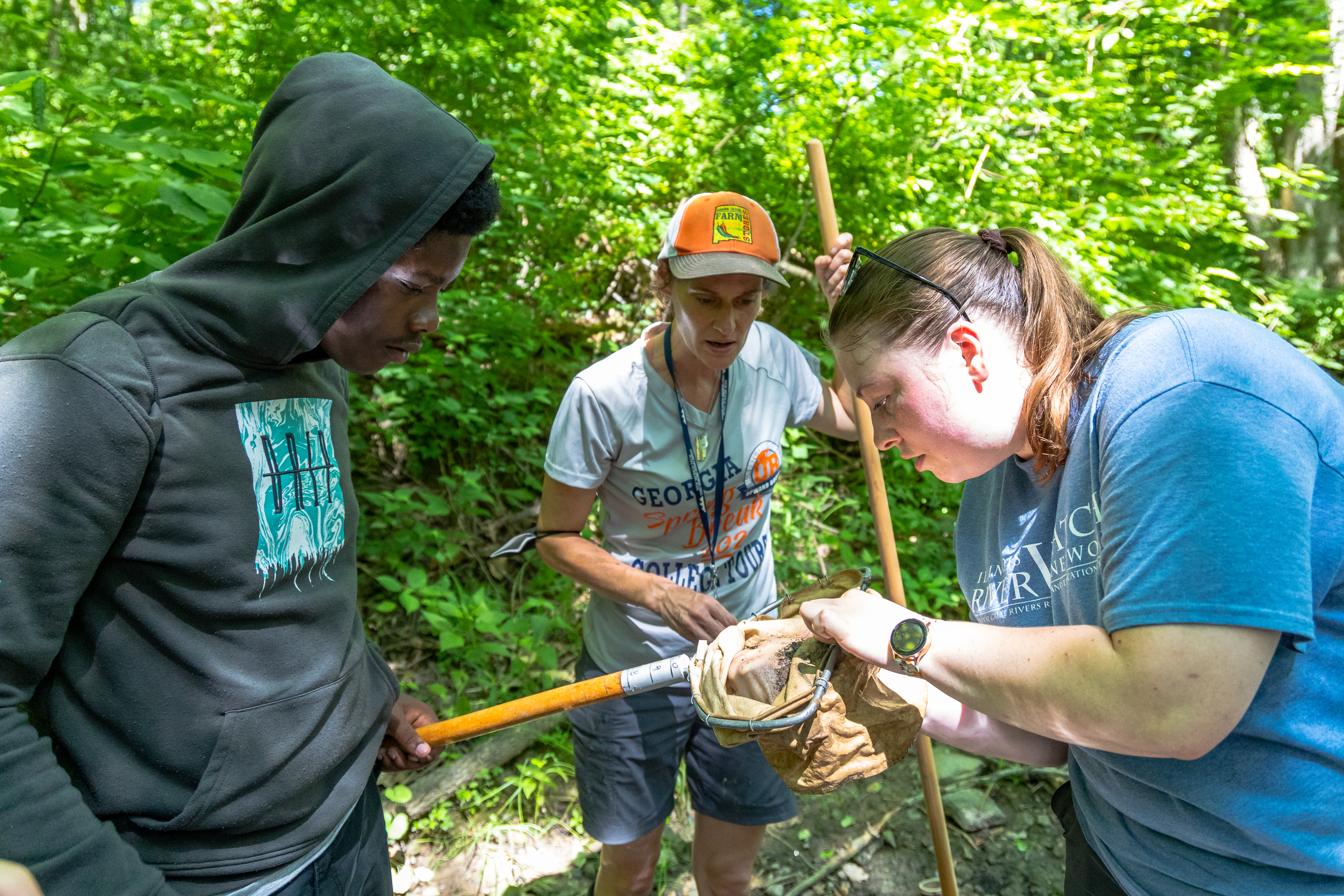 NGRREC staff and volunteers collect stream invertebrates in a net. (NGRREC photo)