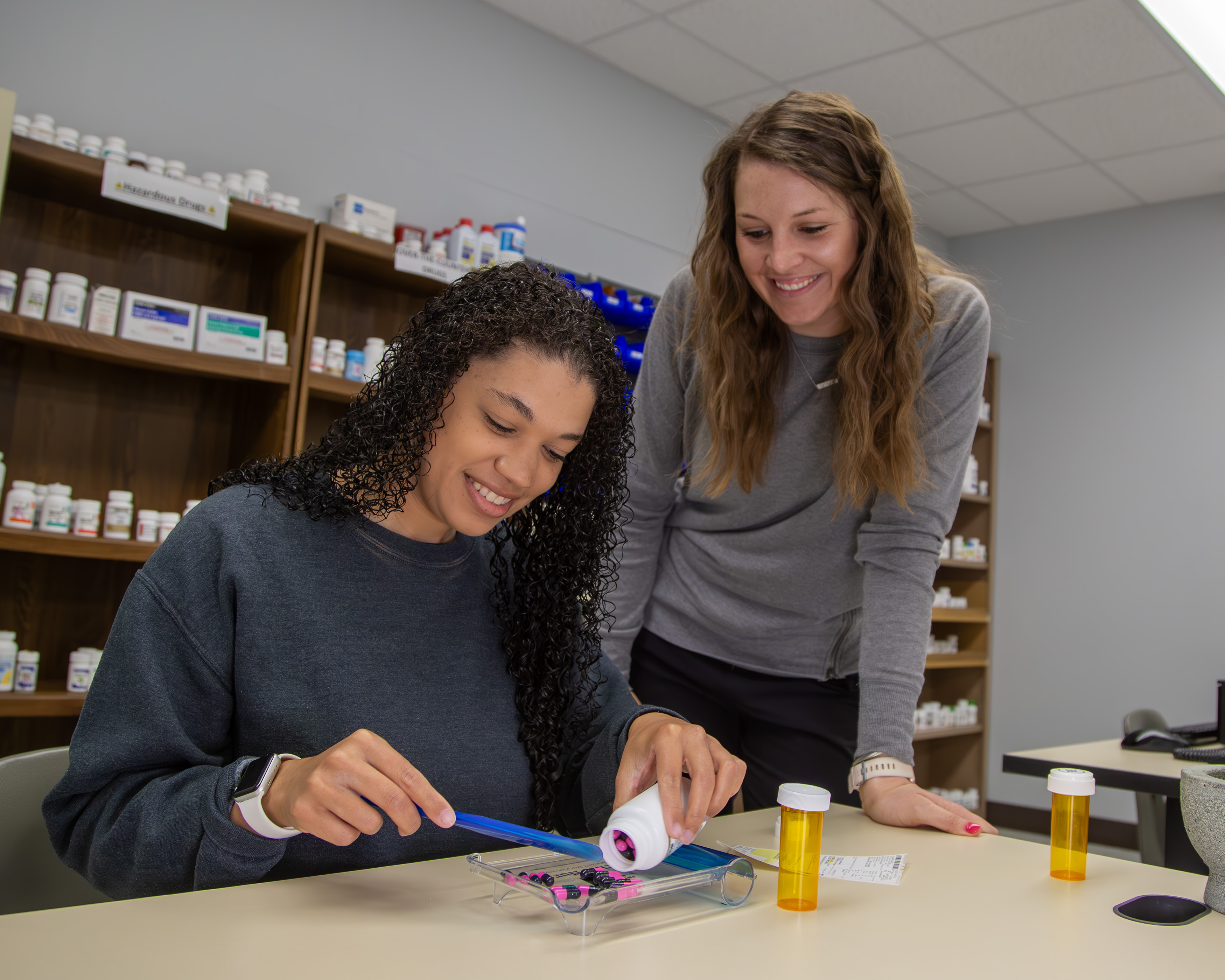 Pharmacy Technician Assistant Professor Kaycilee Sackmann supervises the work of student Jasmine Williams. JAN DONA/L&C MARKETING & PR