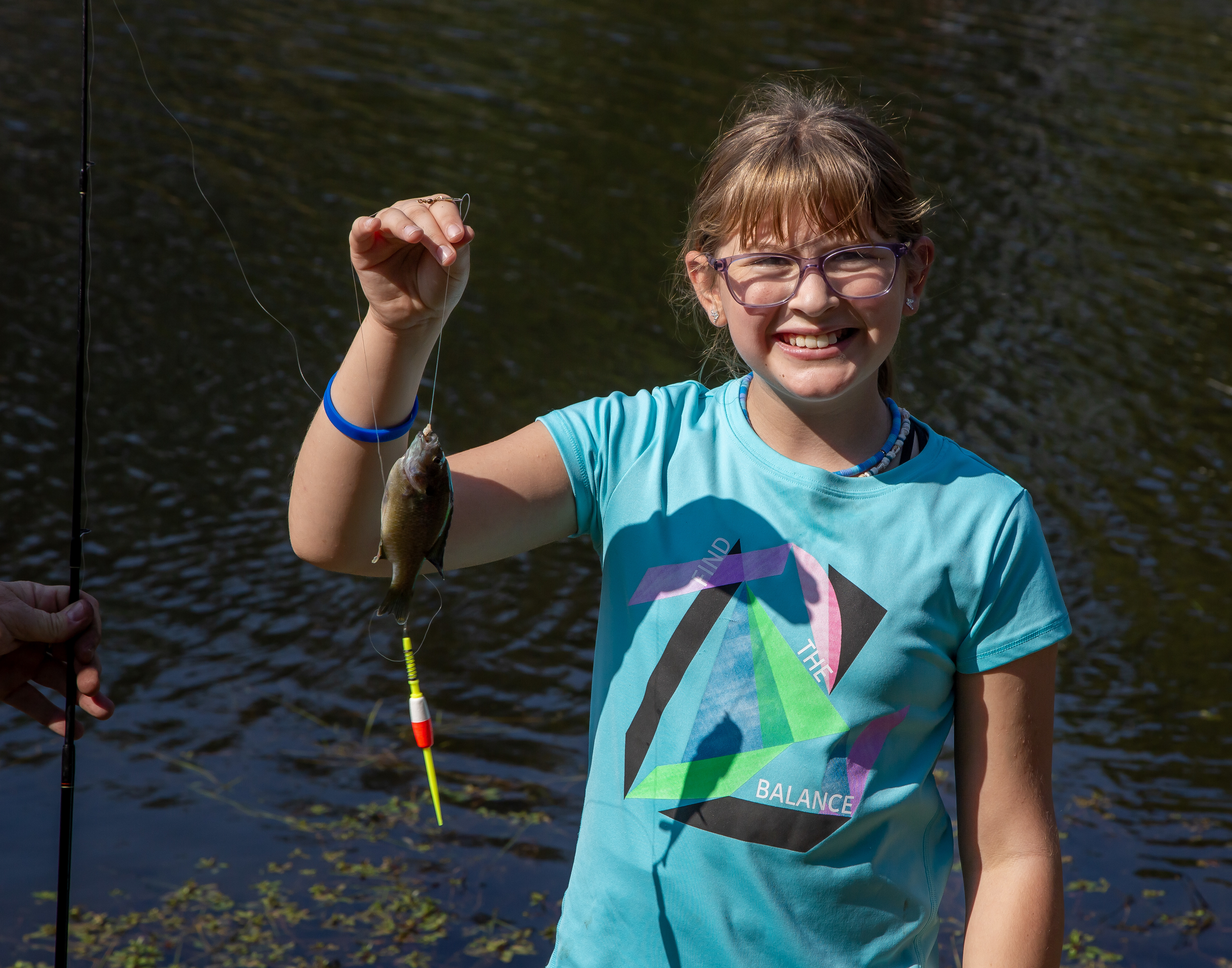 A fifth-grade student holds a fish for a photo during the 2023 Water Festival at Lewis and Clark Community College. JAN DONA/L&C Marketing & PR