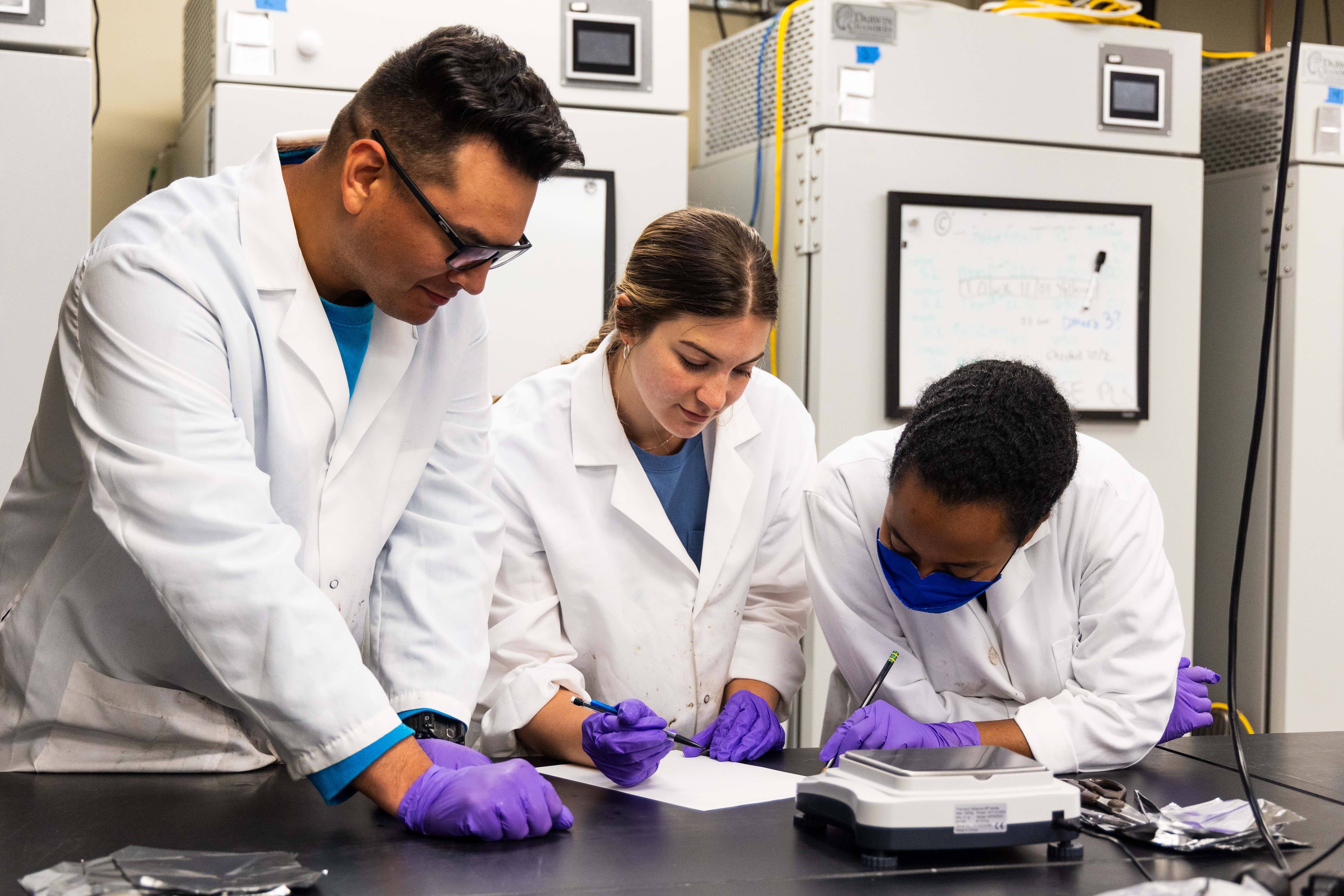 NGRREC NSF REU interns Nathan Palomo, Morgan Trout and Faben Tesfazion record data for aquatic microplastic analysis. JIMMY WILDERMAN/ROUTE 3 FILMS