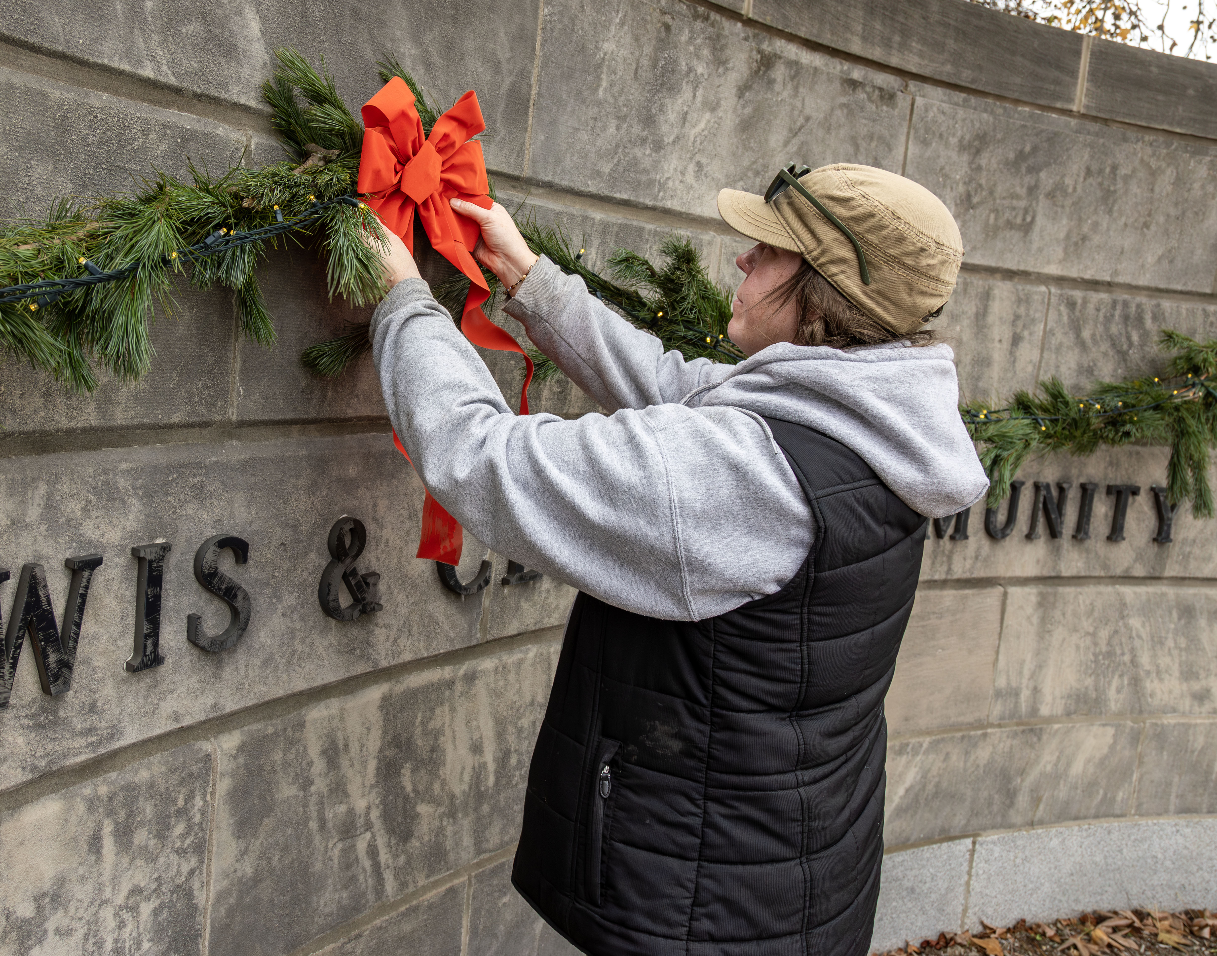 LC Garden Designer Katie Piper installs holiday decorations at the Haskell Gate. 