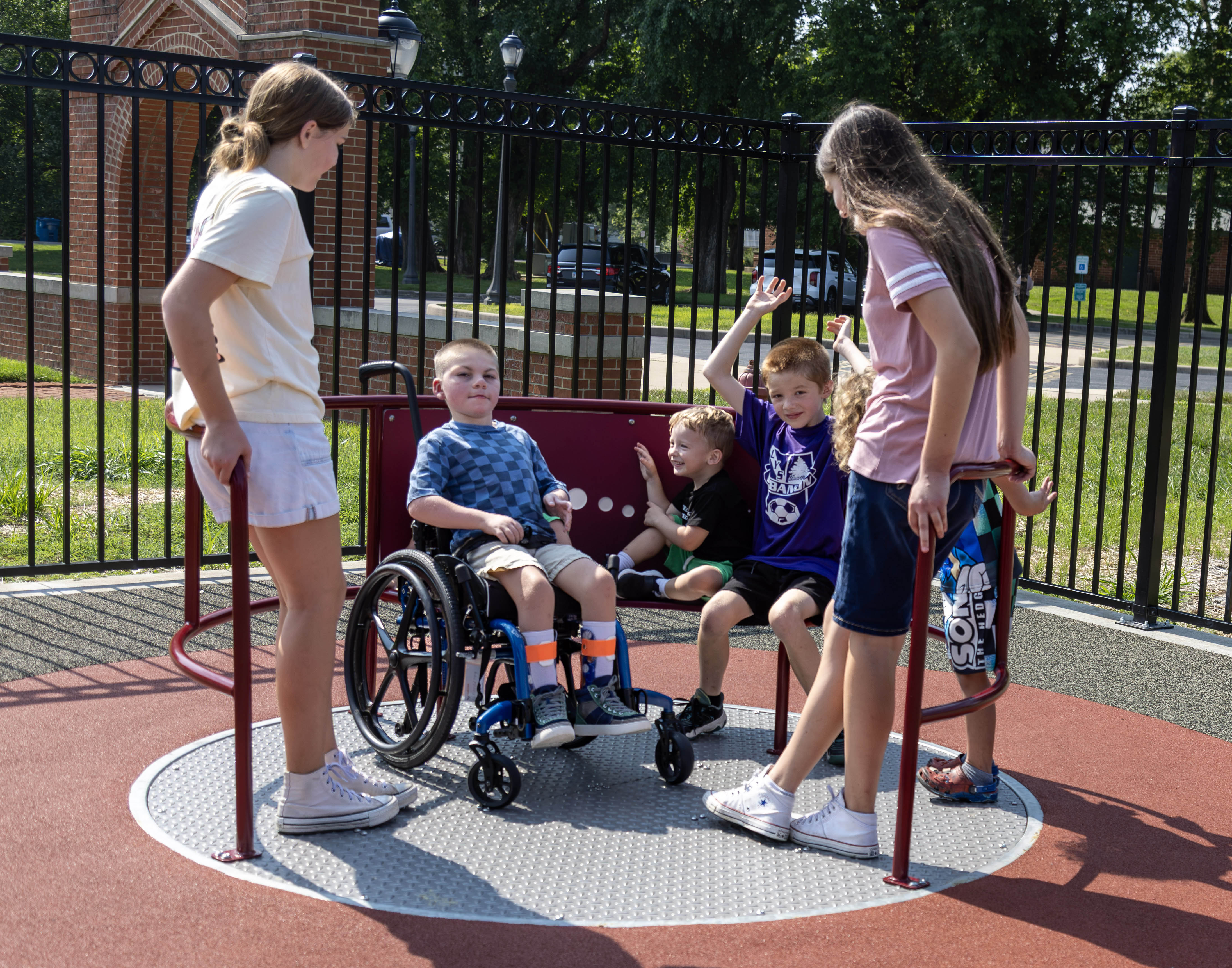 Henry Dunn (wheelchair) enjoys a ride on the accessible merry-go-round with his sisters Madison and Abbigail Dunn, and Luka and Dallas Goble.