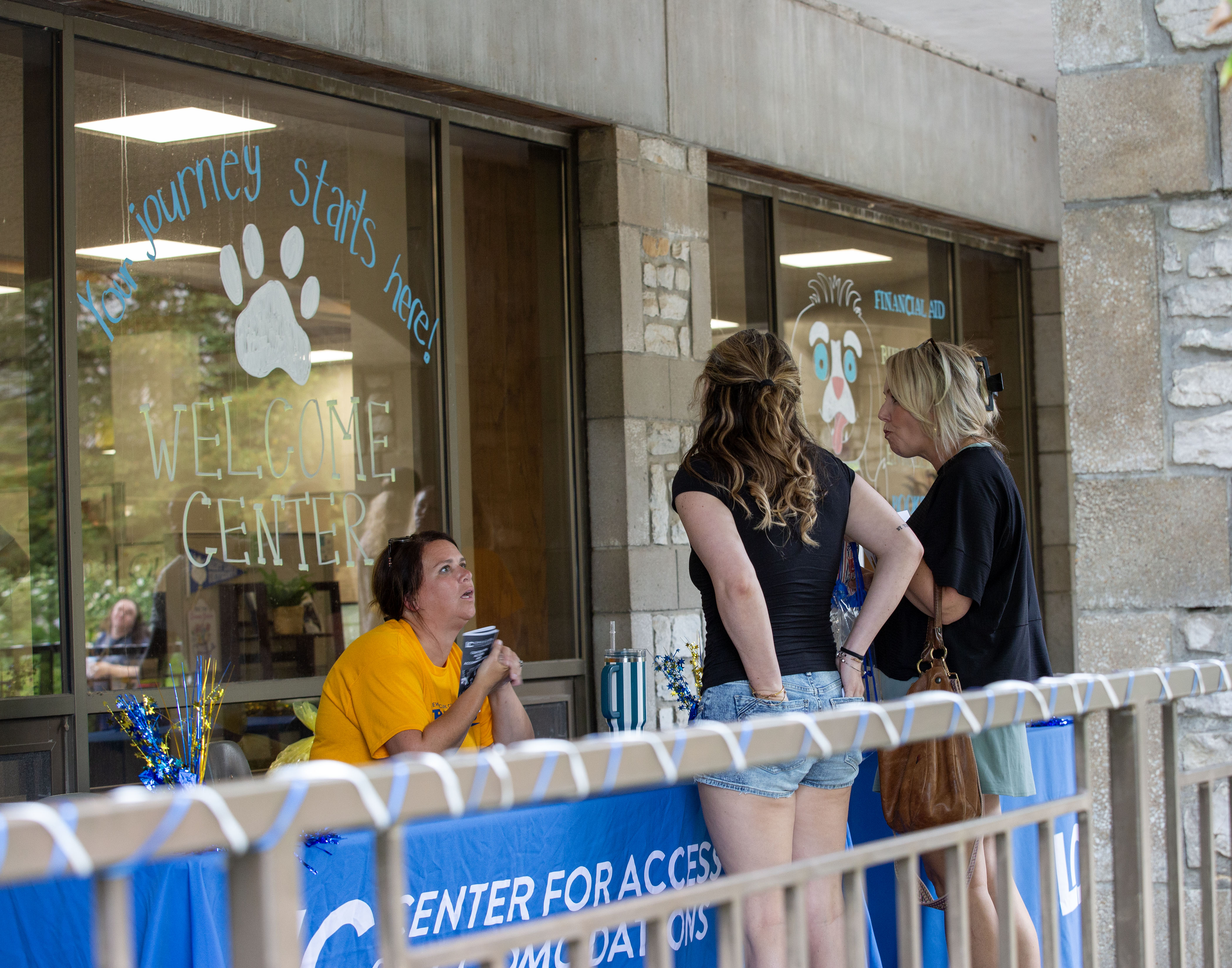 Education Counselor Emily DeGrand speaks with an incoming student and her guest about the services offered by the Center for Access and Accommodations during Trailblazer Welcome Day. 